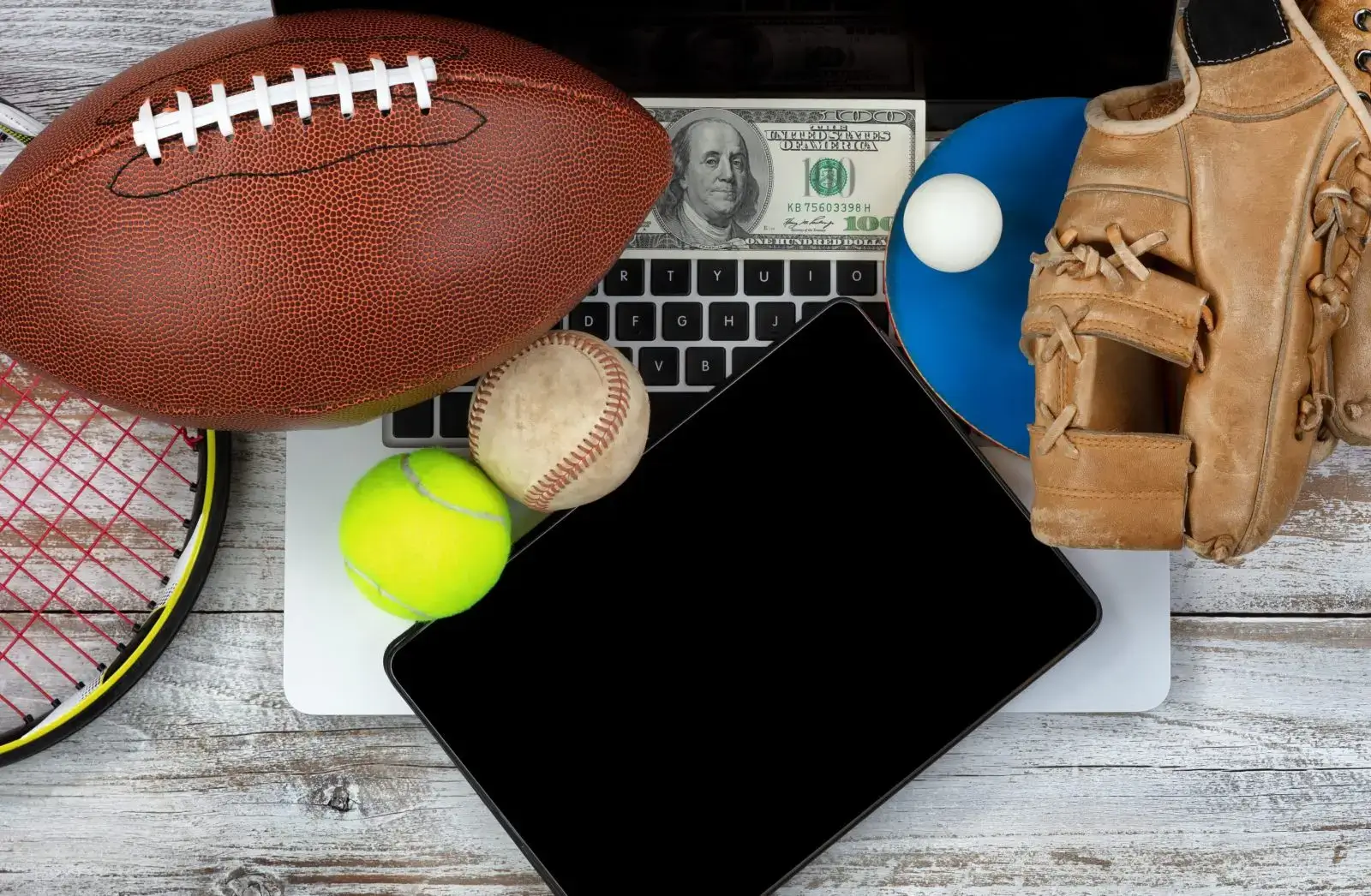 Sports equipment on a laptop with money.